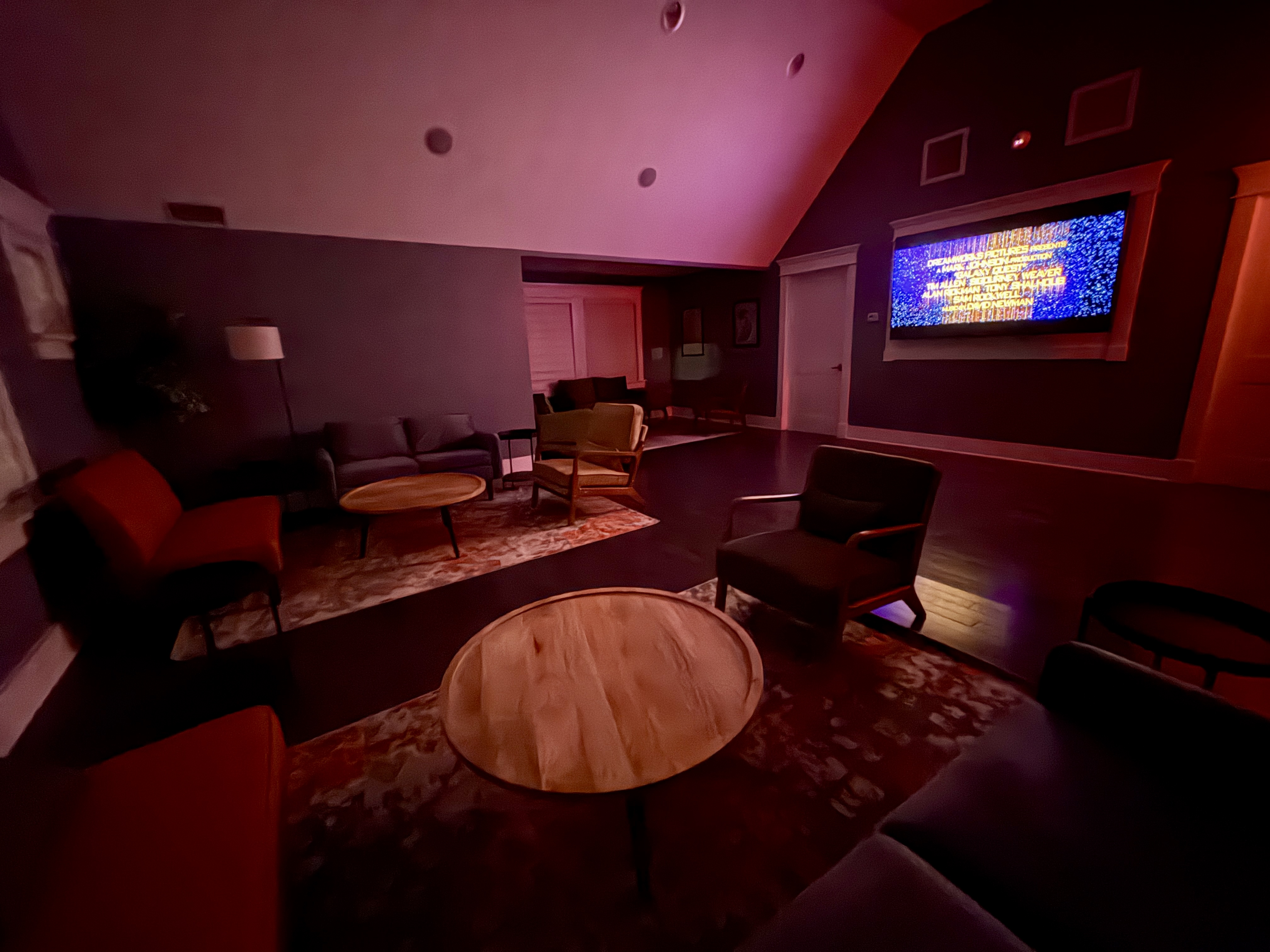 The dim, cozy 21+ lounge at Vernon Brewing with a big screen lit up for movie night